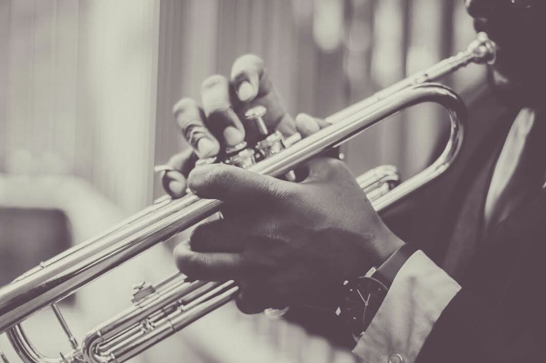 A musician in formal wear playing a trumpet